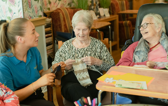 three people talking and knitting